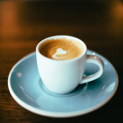 A coffee in a blue cup and saucer